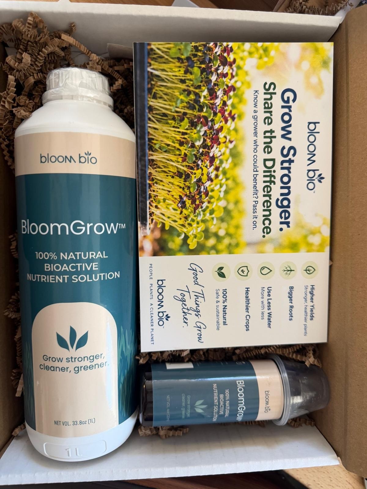 Bloom Bio grower box with a BloomGrow 1 L bottle and a Grow Stronger, Share the Difference card